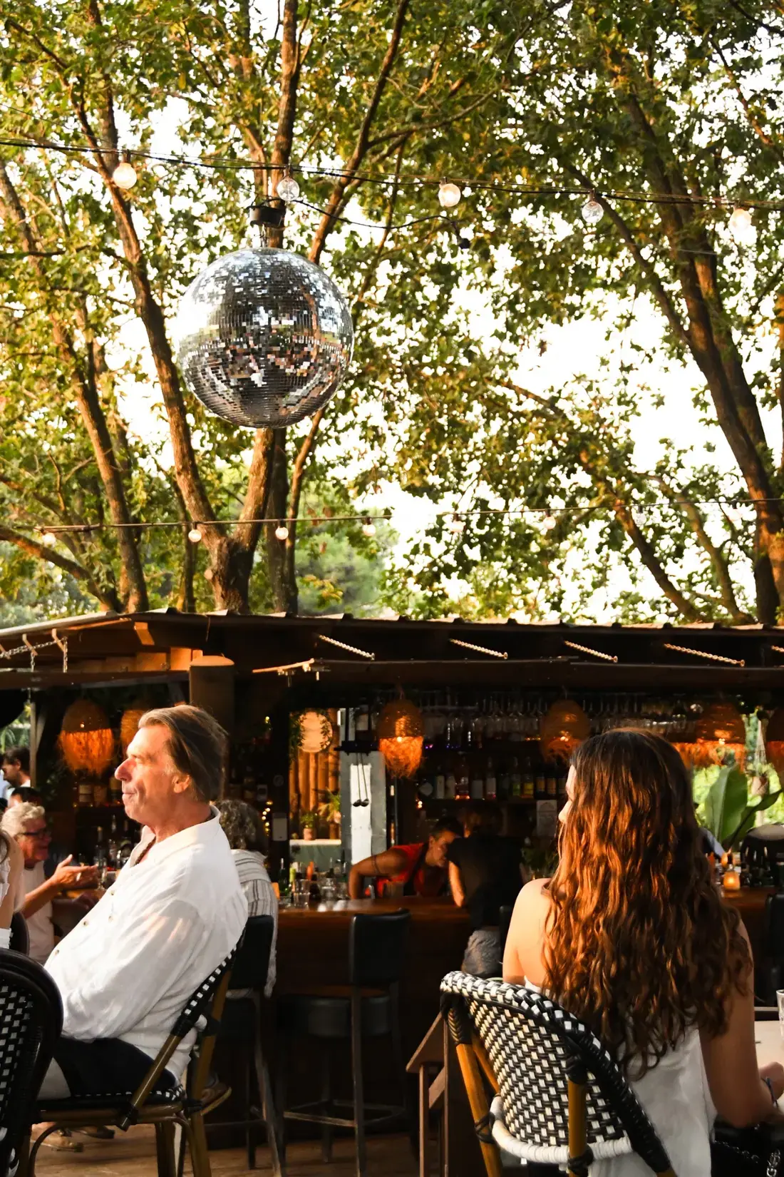 Boule à facettes et ambiance du bar extérieur du Will sous les arbres
