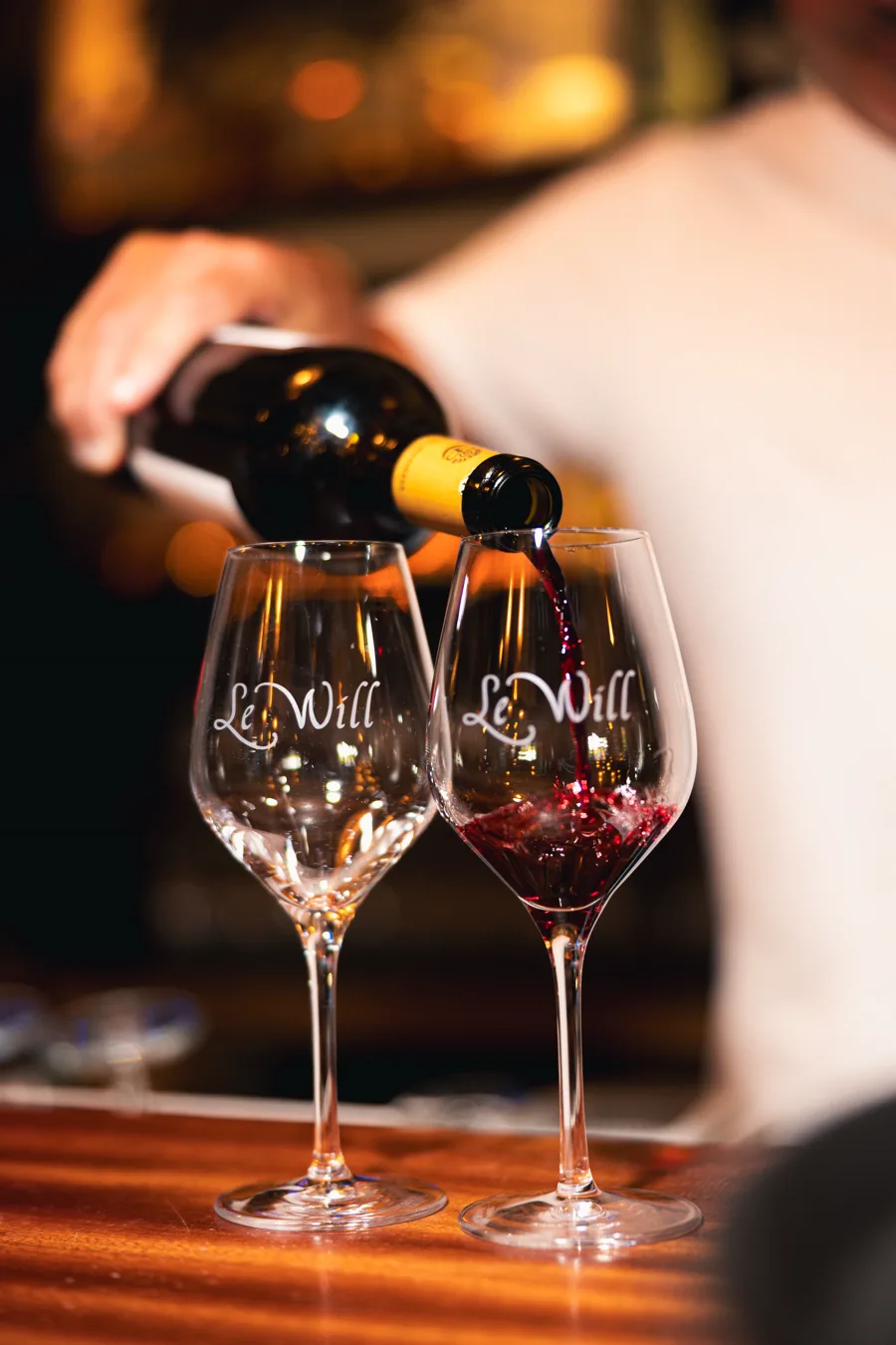 Vin rouge versé dans un verre gravé Le Will