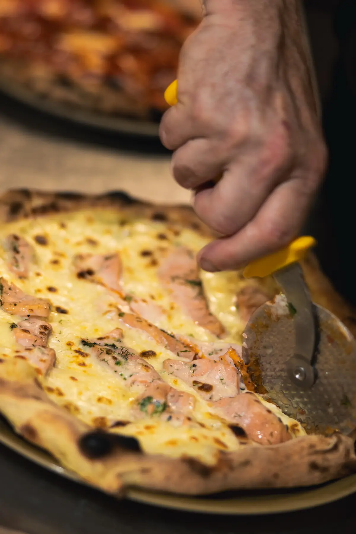 Découpe d'une pizza artisanale préparée au Will